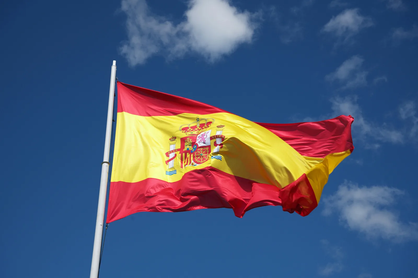 Spanish flag waving against a clear blue sky
