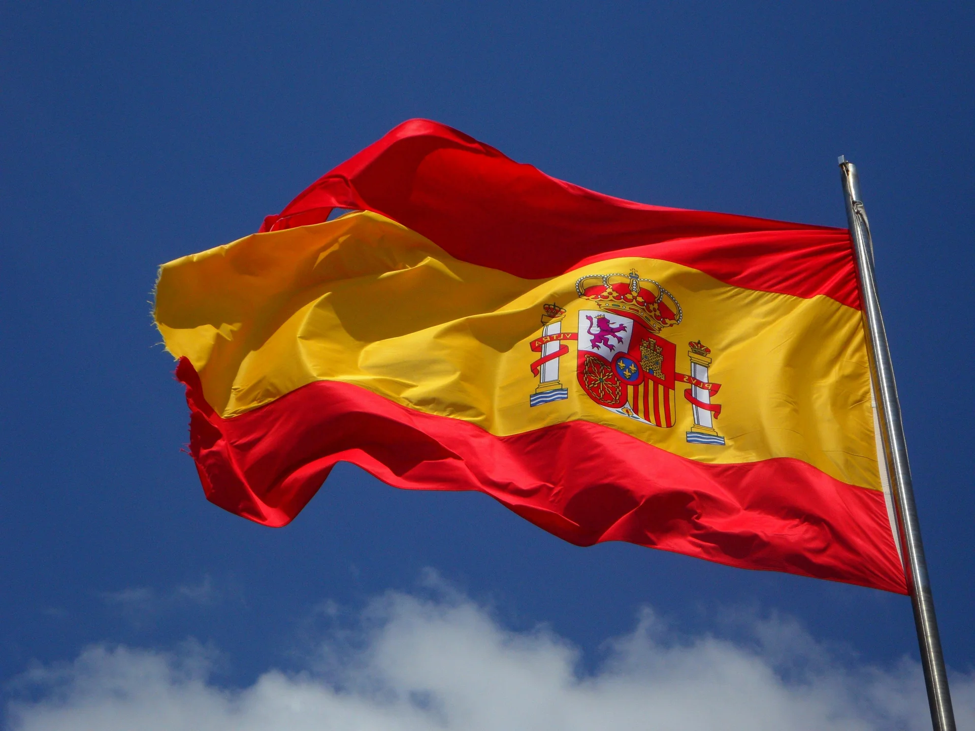 Spanish flag waving against a clear blue sky